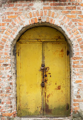 Old rust metal door in brick wall.