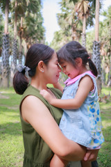 Fototapeta premium young mother and daughter hugging in love playing in the park