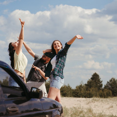 Car traveling. Group of friends enjoying vacation together. Road trip, sightseeing, friendship