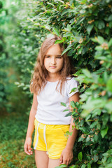 Girl walking in the garden, green plants, shrubs, portrait, greenery, trees, summer and spring, beauty, shorts and t-shirt, vacation from school