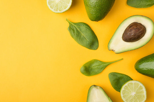 Top Above Overhead View Cropped Photo Of Cut Avocado, Lemons And Baby Spinach Leaves Places To The Right Side Isolated On Yellow Background