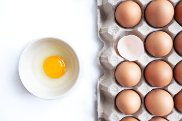 closeup of fresh chicken egg on egg box, panel, on white background with one fragile egg shell for cook for food of meal and fresh and natural egg in bowl
