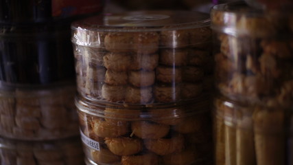 Stack of dried cookies in a plastic container in a cake shop. poor light photo