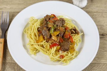 spaghetti au boeuf et poivrons dans une assiette 