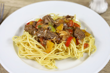 spaghetti au boeuf et poivrons dans une assiette 