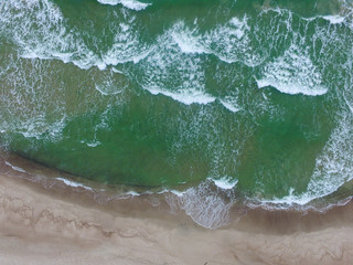 Top view of cold stormy and harsh Baltic sea. Empty off-season beach scene photographed with a drone.