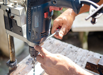 The handyman using screwdriver to prepair drill for his work.