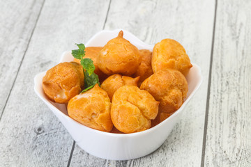 Sweet tasty profiteroles heap in the bowl