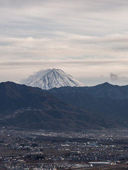 The tip of Mt. Fuji rising above the surrounding mountains