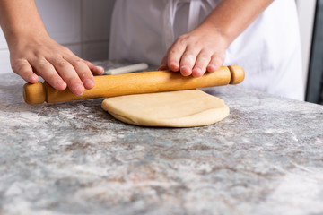 Baker stretches the dough with rolling pins
