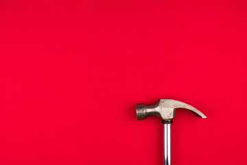 Shining Metal hammer on red background closeup.top view. Space for text