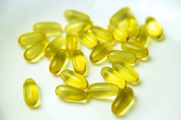 Lots of yellow pills on a white background