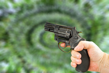Gun in hand on a blurry green background