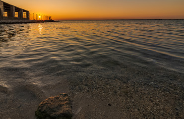 Dramatic sunrise with silky water view in Al uqair ruined fort sea side Saudi Arabia.