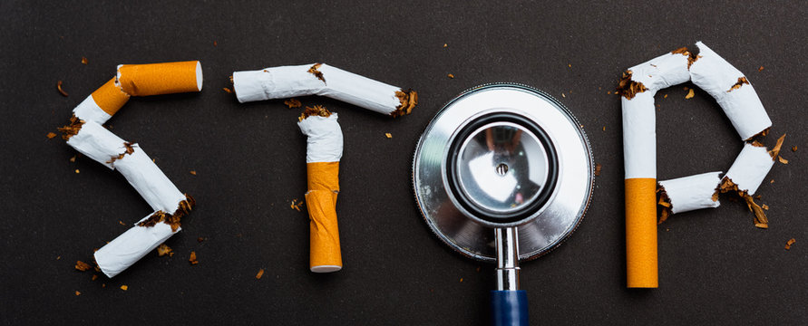 31 May of World No Tobacco Day, no smoking close up word STOP spelled text of the pile cigarette or tobacco and doctor stethoscope on black background with copy space, and Warning lung health concept