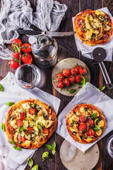 gourmet pizza with tomatoes, olives and basil leaves on wooden table