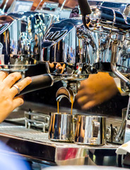 Espresso Machine pouring fresh coffee into cups at Local Coffee Shop..