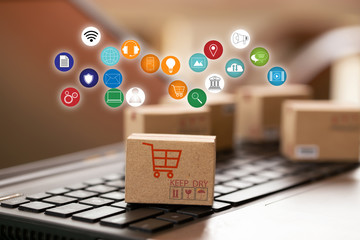 Cardboard box with icon on notebook keyboard. Online shopping, e-commerce and delivery service...