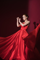 Young beauty woman in fluttering red dress