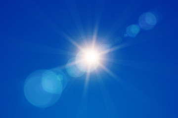 Sun rays on a blue summer sky.