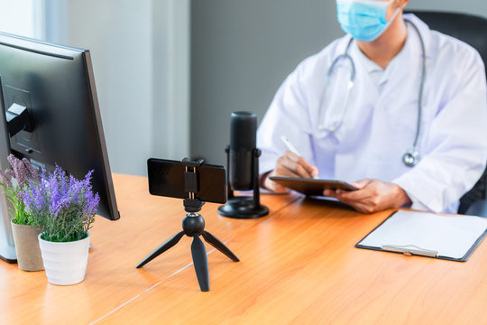 Asian medical team wearing medical masks technology network team meeting concept. Doctor at a table discussing a patients records working, Online medical treatment, New normal