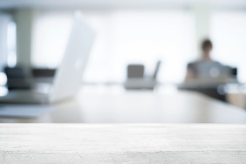 Empty wooden desk space over blurred office or meeting room background. Product display.