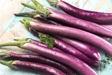 top view of fresh purple japanese eggplants on rustic wooden background