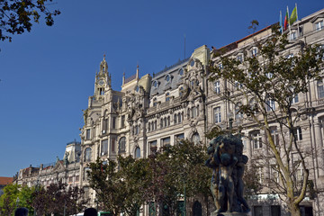 Fototapeta na wymiar Porto, Portugal - August 18, 2015: Beautiful facade of the Bank of Porto, with a statue of cherubs in the foreground.
