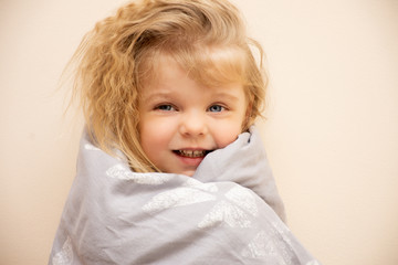 smiling blonde child girl with blue eyes. Joyful emotions of a four year old child.