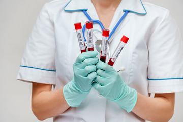 medical doctor nurse woman wearing protective mask and gloves - holding virus blood test tube