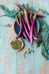 top view of fresh purple japanese eggplants on rustic wooden background