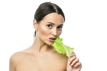 portrait of a girl with clean skin without makeup with a leaf of green salad