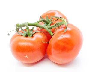 Beautiful ripe red tomatoes are located on a white background
