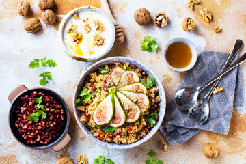 close-up view of tasty healthy couscous salat with figs fruits, nuts and pomegranate seeds