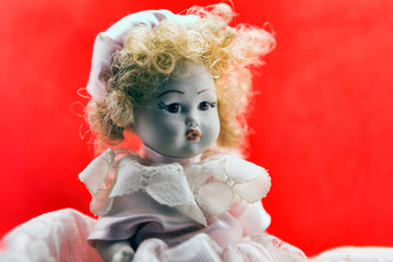 Beautiful vintage porcelain doll portrait with white dress blond hairs and and sweet glance