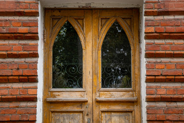 A wooden door in an old brick house.