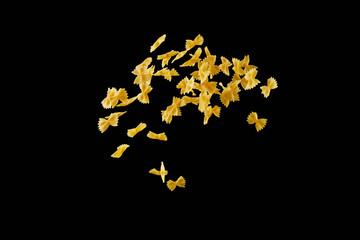 Italian flying raw pasta isolated on black background. macaroni farfalle falling.