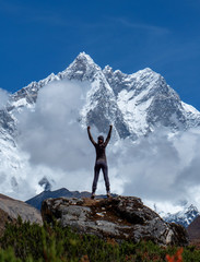 Active woman in trekking enjoying the view of mount Everest landscape with rising hands up