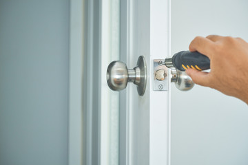 Fototapeta premium locksmith home service with silver handle and screwsriver on white door