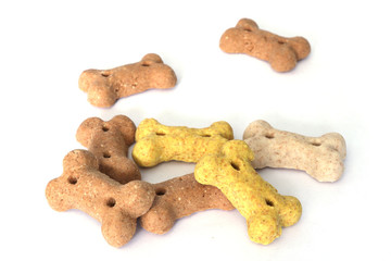 Fototapeta premium Goodies for dogs. Bone-shaped cookies for dogs. Isolated dog treats. Multi-colored bones of cookies on a white background.