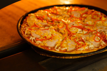Baking a pizza in oven. Hot pizza in a dish on a shovel in a furnace.