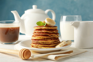 Composition with pancakes, milk and cocoa drink on wooden table. Sweet breakfast