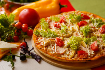 Hot italian pizza on a table with vegetables