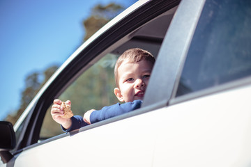 Little boy peeps out of a car window