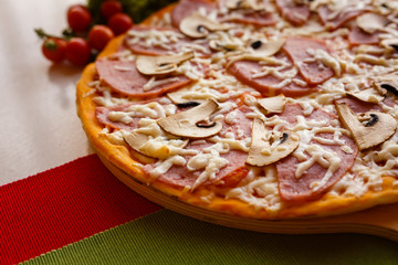 Hot italian pizza on a table with vegetables