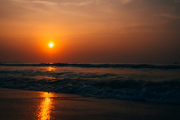 waves at sea against the orange sunrise