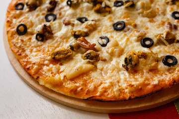 Hot italian pizza on a table with vegetables