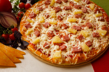 Hot italian pizza on a table with vegetables