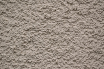 Gray wall for the backdrop. Rough surface, cracks, grooves, pimples. Color - Cloudy.