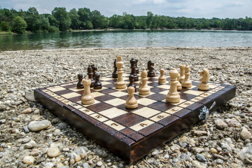 Playing chess near the lake Štrkovisko in Senec, Slovakia. Chessboard on a stone beach with a great landscape